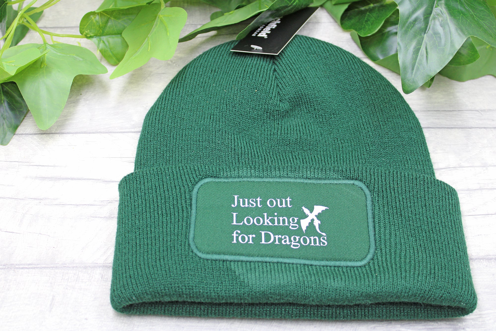 Flat lay of Just Out Looking for Dragons beanie on rustic wood