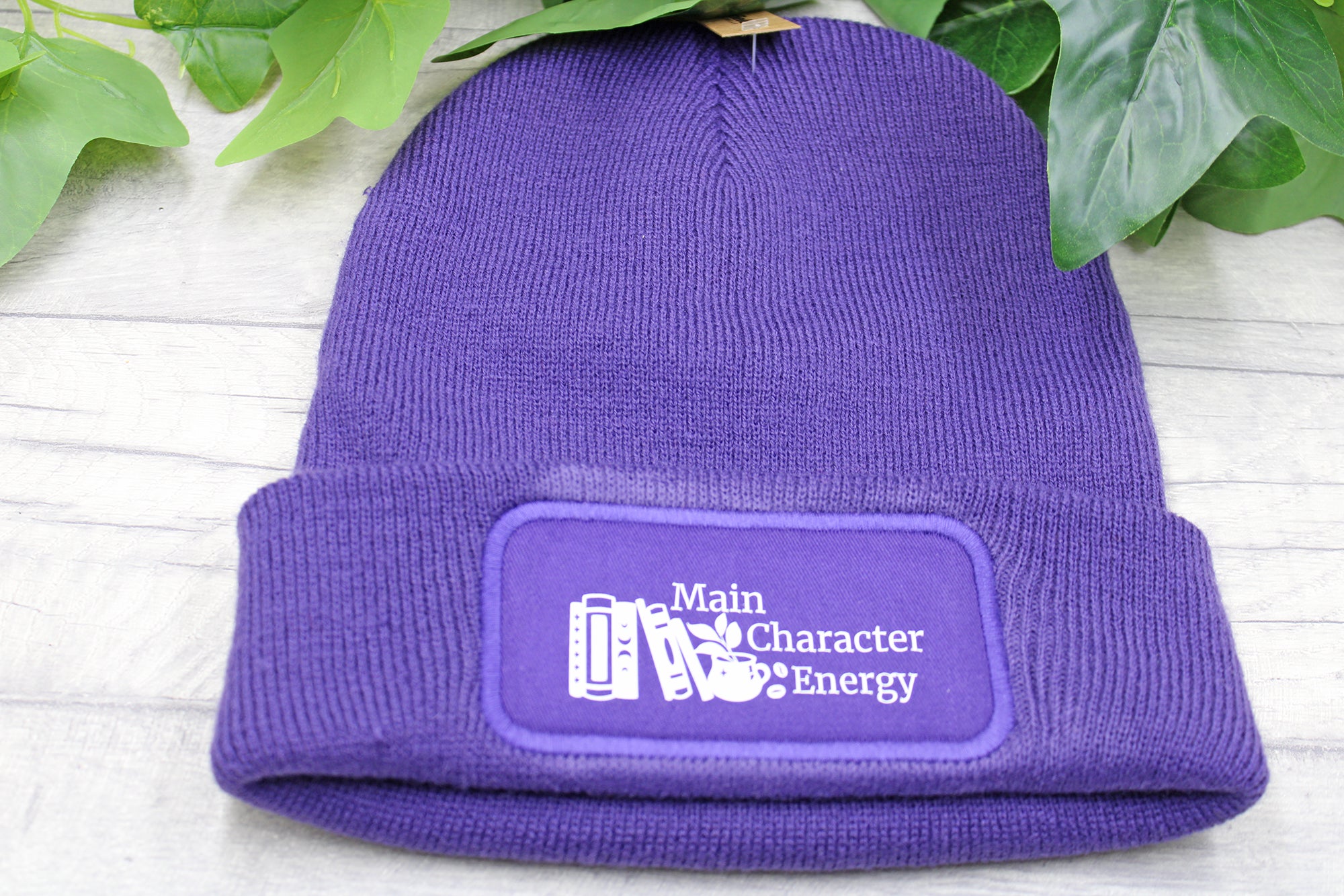 Close-up of vinyl printed Main Character Energy text on knit hat