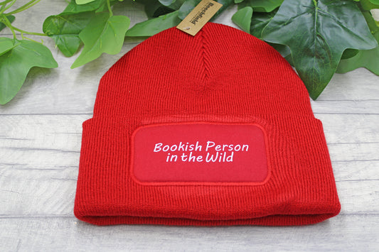 Flat lay of Bookish Person in the Wild beanie on rustic wood