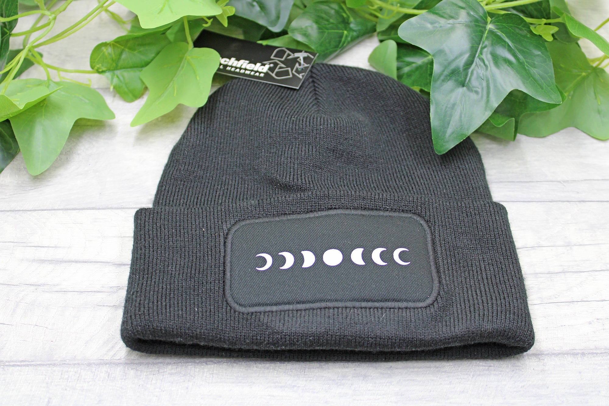 Flat lay of moon phases beanie hat on rustic background
